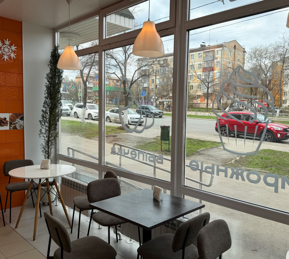 A steaming cup of coffee surrounded by cozy blankets and warm decor in a sunlit room.